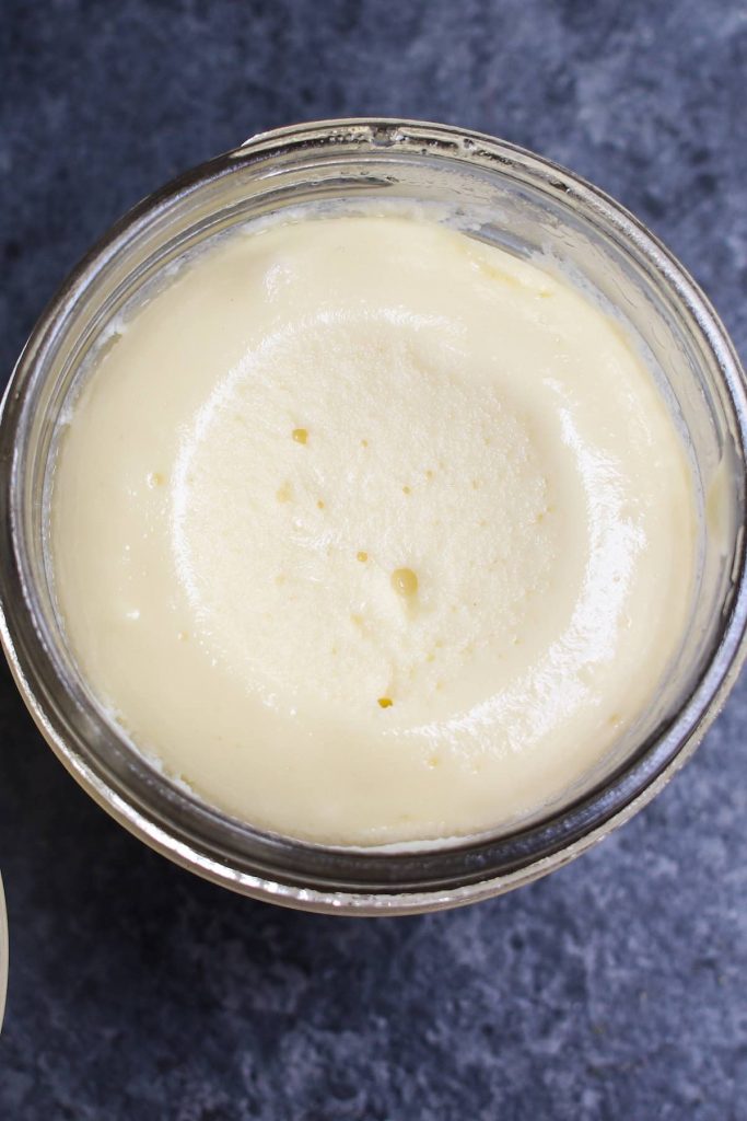 Primer plano de la textura suave y cremosa de la tarta de queso al vacío en un tarro.