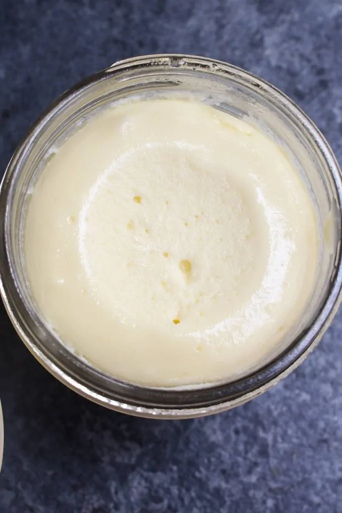 Primer plano de la textura suave y cremosa de la tarta de queso al vacío en un tarro.
