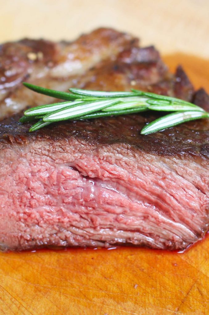 Vista transversal de un bistec rib-eye cocinado a un punto de cocción medio-poco hecho.