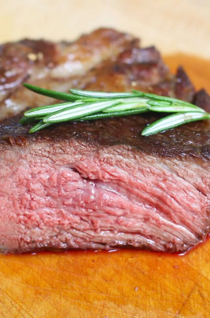Vista transversal de un bistec rib-eye cocinado a un punto de cocción medio-poco hecho.