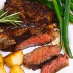 Estos filetes de chuletón al vacío se cocinan a la perfección en un baño de agua tibia y luego se untan rápidamente con mantequilla en la sartén para obtener una hermosa y sabrosa corteza marrón. Es tan tierno, jugoso y realmente simple de hacer en casa. ¡Te recordará a los de tu asador favorito! #SousVideRibeye #SousVideRibeyeSteak